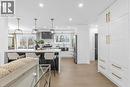Kitchen featuring a kitchen breakfast bar, light stone countertops, white cabinetry, light wood-type flooring, and stainless steel appliances