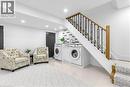 Laundry area with recessed lighting and light tile patterned flooring