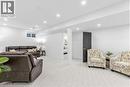Living area with light carpet and recessed lighting