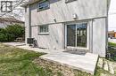 Entrance to property with a patio area, stucco siding, and a lawn