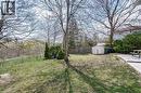Fenced backyard featuring a storage shed and a patio area