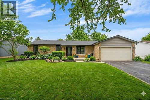 *VIRTUALLY EDITED* Ranch-style home with a garage, driveway, a porch, and a front yard