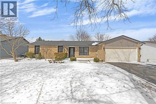 Ranch-style house featuring an attached garage, driveway, and brick siding