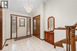 Entryway featuring a chandelier, vaulted ceiling, and light tile patterned flooring