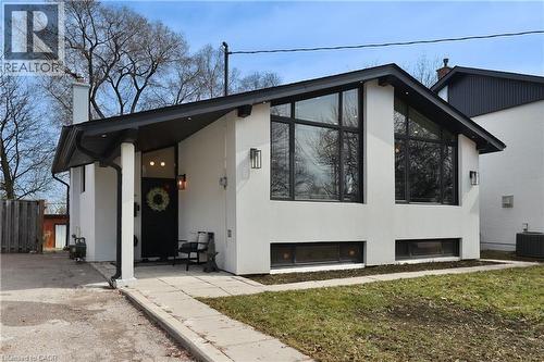 View of front of property featuring a chimney, stucco siding, and a front yard