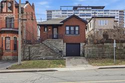 View of front of property featuring brick siding, stone siding, concrete driveway, and an attached garage