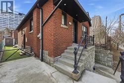 View of property exterior featuring brick siding and a shed