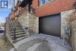 View of exterior entry featuring stone siding, a garage, and driveway