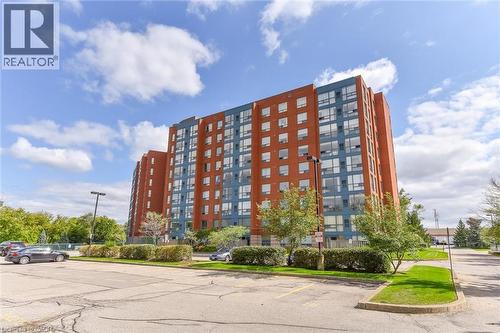 View of apartment building / complex featuring uncovered parking