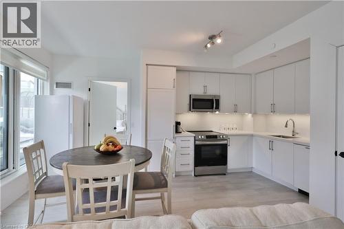 Kitchen featuring stainless steel appliances, light countertops, white cabinets, and light wood-style flooring