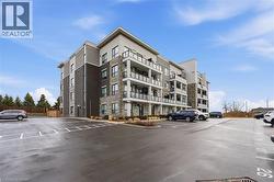 View of apartment building / complex with uncovered parking