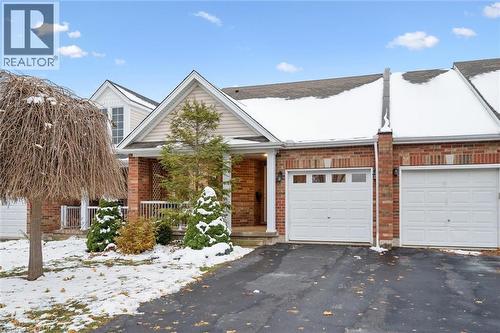 View of front of home featuring brick siding, driveway, and an attached garage
