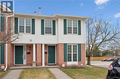 View of front facade with covered porch, a front yard, and brick siding