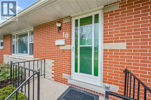 Property entrance with a porch and brick siding