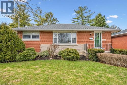 View of front of home featuring brick siding, a front lawn, and a shingled roof