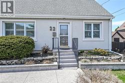 Property entrance with roof with shingles and stucco siding