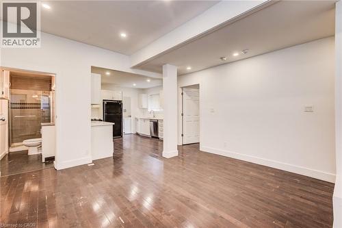 Main floor living room with dark wood-style flooring and recessed lighting