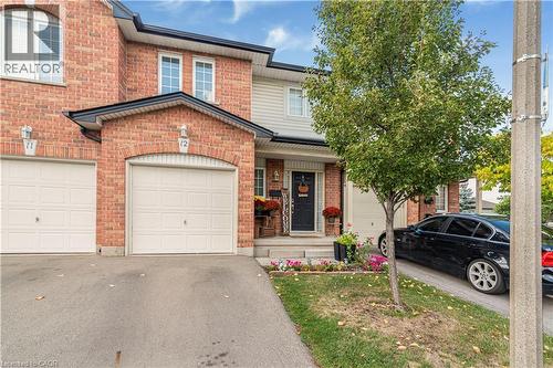 Traditional home with driveway, brick siding, a porch, and a garage