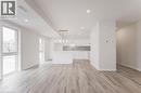 Open concept living space featuring light-toned flooring, recessed lighting, and large windows providing natural light