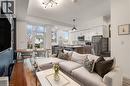Open concept living area featuring hardwood flooring, recessed lighting, and large windows
