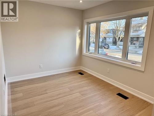 Room with light wood-style flooring, white baseboards, and a large window providing natural light