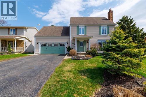 The property features a two-story exterior with light-colored siding, a dark roof, and a prominent brick chimney