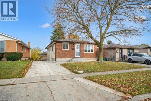 The property features a brick exterior, a paved driveway, and a front lawn