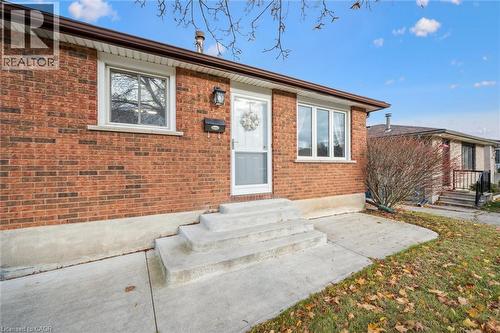 The property features a brick exterior with white trim windows and a white storm door