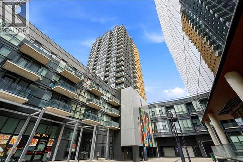 The property features contemporary architecture with a blend of glass and paneling, private balconies, and a clear blue sky overhead