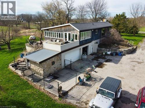 The property features a stone and wood exterior, with a garage and an expansive grassy area