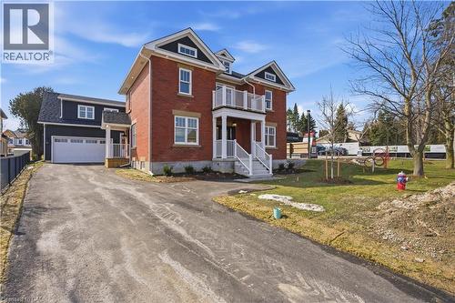 This property features a brick exterior with white trim and a prominent white balcony