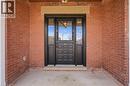 The property features an inviting entrance with a paneled door and sidelight windows, set within a red brick facade