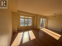 Spacious interior featuring wood-finish flooring, a large window with blinds, and a sliding glass door