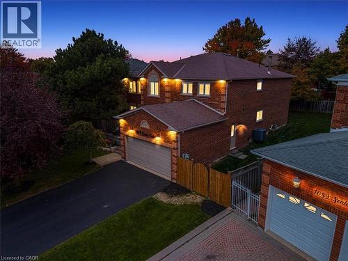 Brick exterior residence featuring a two-car garage with a paved driveway
