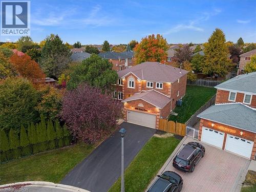 Brick two-story residence featuring a two-car attached garage, asphalt driveway, and a fenced backyard