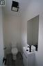 Powder room featuring a white pedestal toilet, floating vanity with an integrated sink, matte black faucet, and a wall-mounted mirror