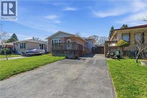 Exterior featuring a raised deck, light brick facade, and a paved driveway