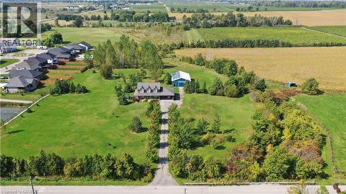 Aerial view of all brick house and 36' by 52' shop complete with bunkie and two lofts.