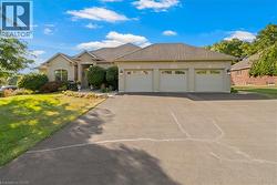 Brick exterior with a prominent three-car garage and asphalt driveway