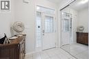 Entryway featuring a white door with decorative glass inserts, flanking sidelights, and a transom window