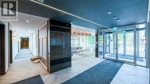 Entry foyer with herringbone wood-finish flooring, dark ceiling with recessed lighting, and a linear light fixture