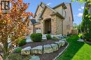 Brick facade residence featuring an arched entryway, gabled rooflines, and a two-car garage.