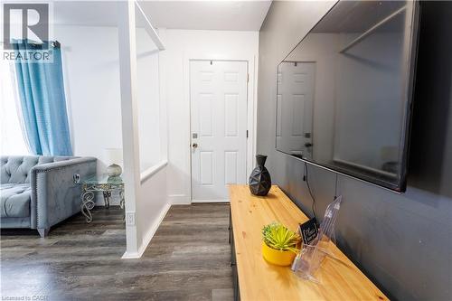 Entryway featuring wood-finish flooring, a white paneled door, and white baseboards