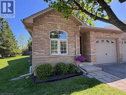 Vaulted ceiling, tile flooring, built-in wall sconce, wood railing, kitchen with wood-finish cabinetry