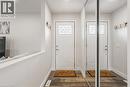 Entryway featuring a white paneled door with decorative glass, wood-finish flooring, a mirrored closet door, and a half-wall partition