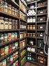 Custom pantry featuring extensive dark wood-finish shelving, integrated storage for small appliances, and woven basket storage solutions