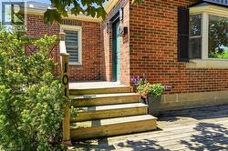 Front entry featuring a wood deck and steps leading to a teal door