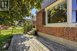 Wood deck with step-up entry, brick exterior, and large window