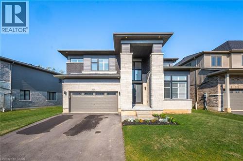 Contemporary residence featuring a stone and siding exterior, an integrated two-car garage, and an inviting covered entry