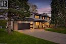 Traditional-style residence featuring a stone and siding exterior, multi-pane windows, and a dark asphalt shingle roof